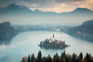 Morning view across Lake Bled to the island church and clifftop castle from Ojstrica, Slovenia.