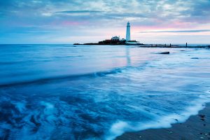 Sunrise at Saint Mary's Lighthouse on Saint Mary's Island, situated north of Whitley Bay, Tyne and Wear, North East England. Seen at sunrise from the beach beside the causeway that runs out to the island. Whitley Bay is situated just north of Newcastle.