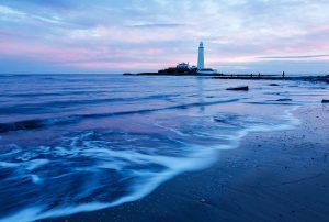 Sunrise at Saint Mary's Lighthouse on Saint Mary's Island, situated north of Whitley Bay, Tyne and Wear, North East England. Seen at sunrise from the beach beside the causeway that runs out to the island. Whitley Bay is situated just north of Newcastle.