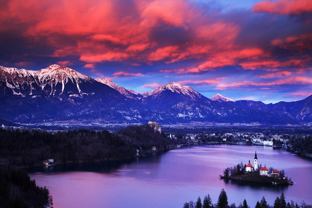 Magnificent sunset colours across Lake Bled and the island church and clifftop castle, seen from Ojstrica, Slovenia.