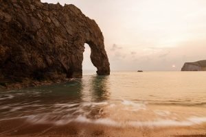 Durdle Door beach as the sun sets, Dorset, England. Durdle door is one of the many stunning locations to visit on the Jurassic coast in southern England.