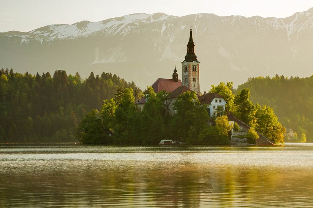 Morning spring light at Lake Bled's island church with the Karavanke Mountains behind, Slovenia.
