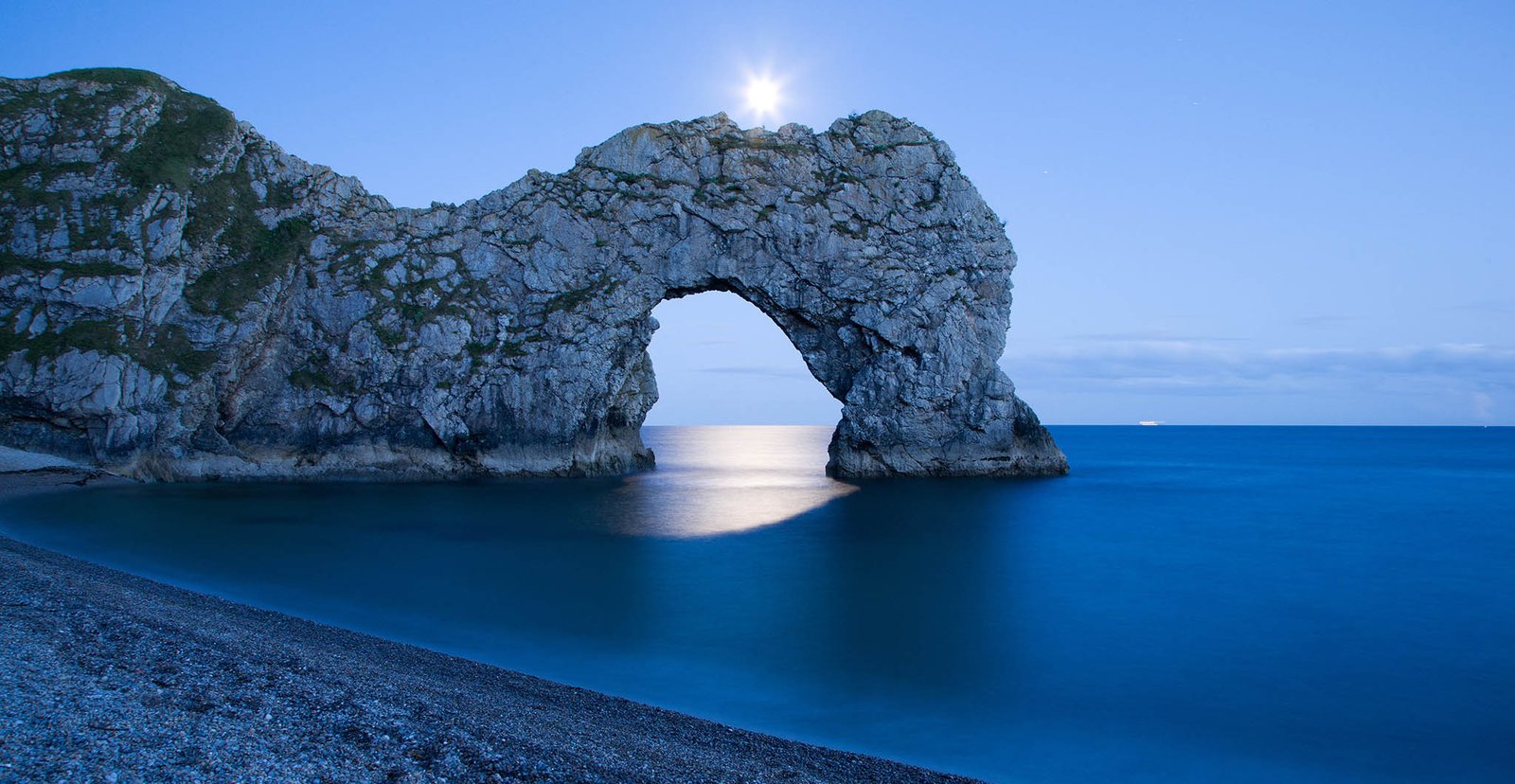 Durdle Door in the moonlight, Dorset, England. Captured late evening as the moonlight flooded through the rock's archway. Durdle door is one of the many stunning locations to visit on the Jurassic coast in southern England.