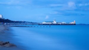 Bournemouth Pier and seafront at dusk. Highcliffe can also be seen on the far right.