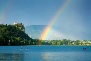 Beautiful light across to the beautiful Lake Bled's hilltop castle as a storm blows over and produces a rainbow. Slovenia.