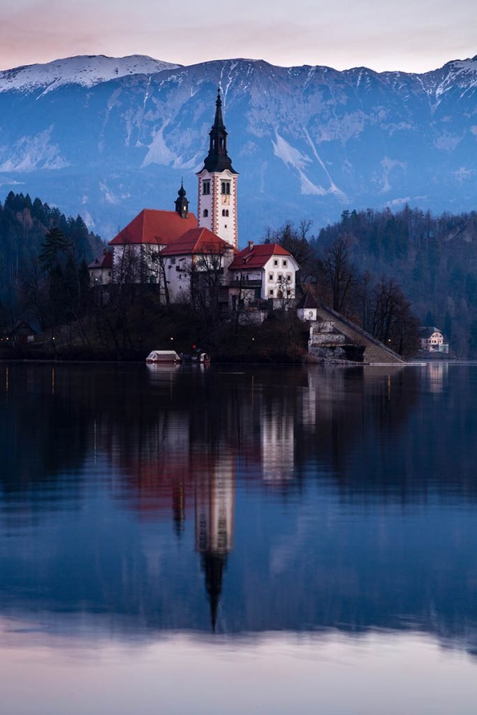 Morning light at Lake Bled's island church with the Karavanke Mountains behind, Slovenia.