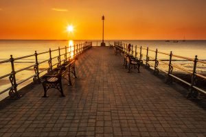Sun rising behind the old cobbled Banjo Jetty in Swanage, Dorset, England.
