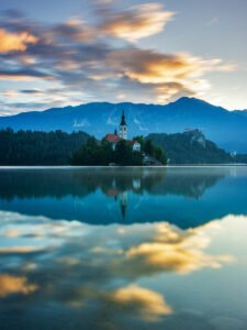 Lake Bled and the island church of the assumption of Mary with the Karavanke mountains in the background at sunrise, Slovenia.