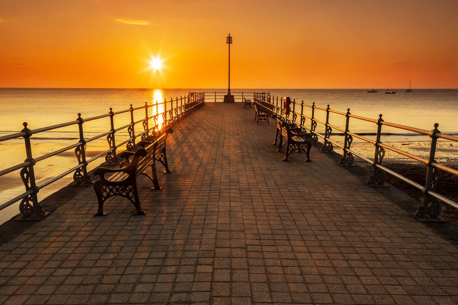 Sun rising behind the old cobbled Banjo Jetty in Swanage, Dorset, England.