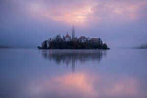 Sunset breaks through the mist over Lake Bled, Slovenia