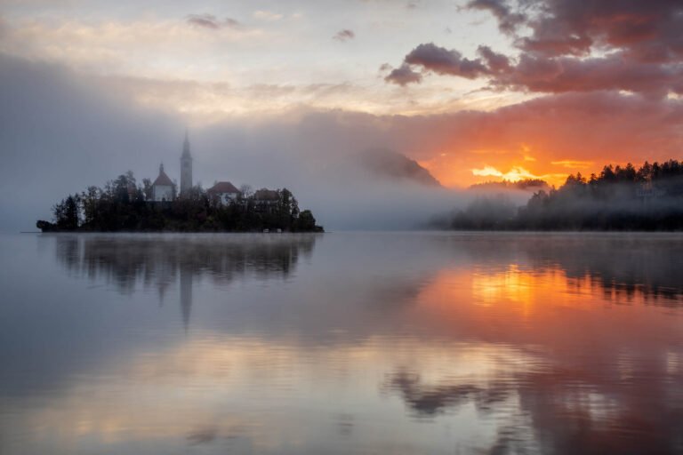 Sun rising over Lake Bled and the island church of the assumption of Mary, Slovenia.