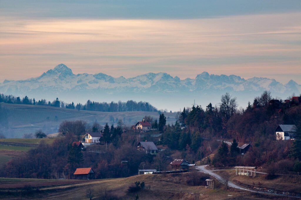 View across the village of Volavlje to the Julian Alps mountains in the west. Volavlje is a small village in the hills east of Ljubljana, Slovenia.