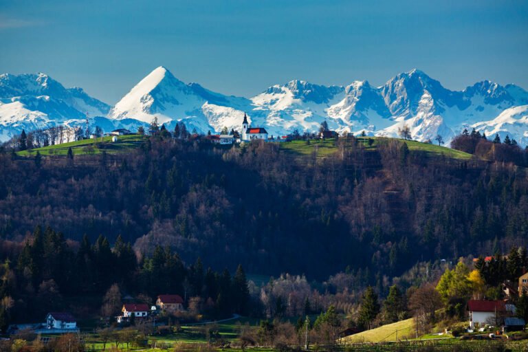 The church of Saint Nicholas in Jance in the hills to the east of Ljubljana, Slovenia. The snow covered Kamnik Alps form a beautiful backdrop.