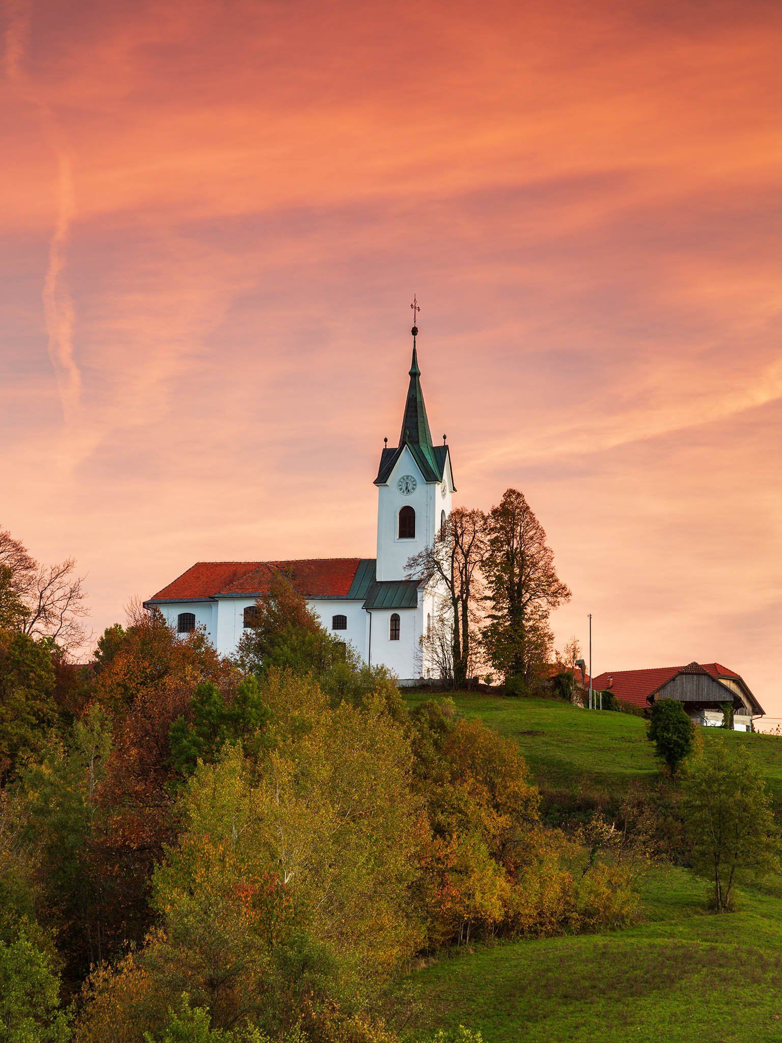 Sunset over the church of Saint Margaret (Marjeta) in Prezganje in the hills to the east of Ljubljana, Slovenia.