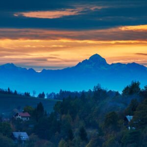 View at sunset across the village of Volavlje to the Mount Triglav in the Julian Alps mountains. Volavlje is a small village in the hills east of Ljubljana, Slovenia.